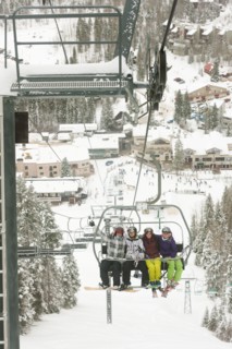 Friends riding ski lift