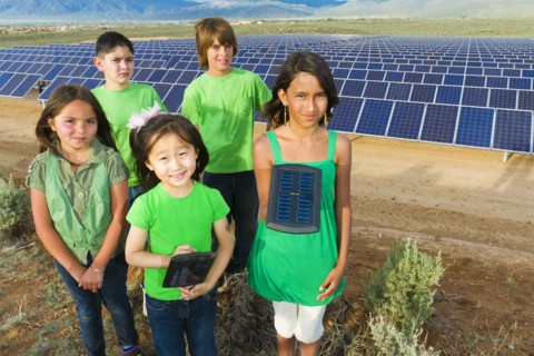 Children standing together in solar panel field