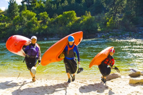 Caucasian family carrying kayaks