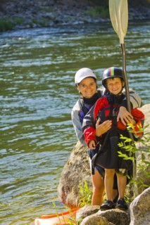 Caucasian mother and son with kayak near river