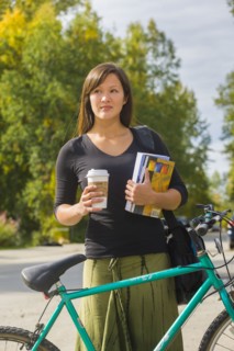 Alaskan woman carrying coffee and school books