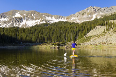 Hispanic woman riding paddle board