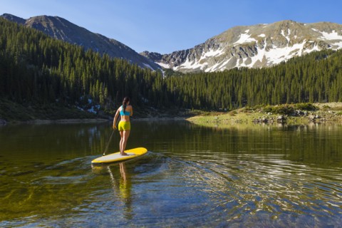 Hispanic woman riding paddle board