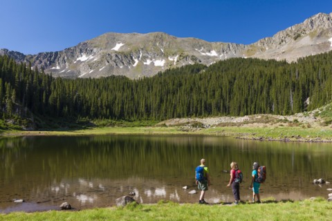 Hikers admiring still lake in rural landscape