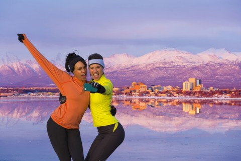 Women posing for cell phone selfie near mountain river