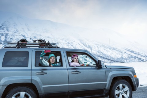Friends photographing from car in winter