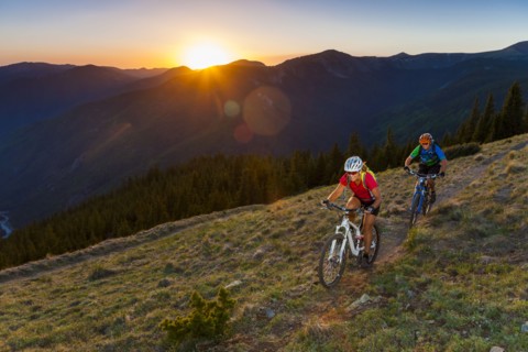 Caucasian couple mountain biking on trail