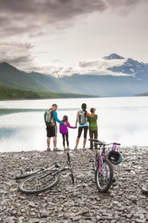 Couple with son and daughter riding bicycles near lake