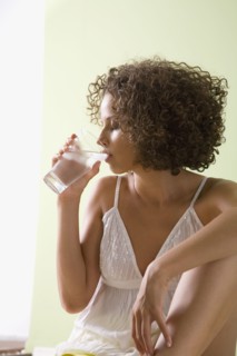 Mixed race woman drinking glass of water