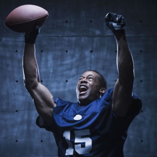 African football player cheering with arms raised