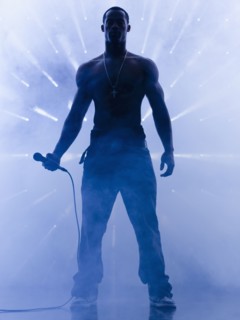 Back lit African singer holding microphone