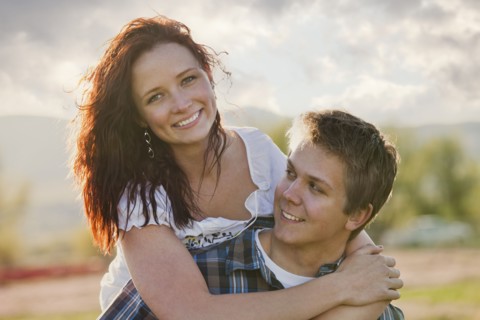Caucasian man giving girlfriend piggyback ride