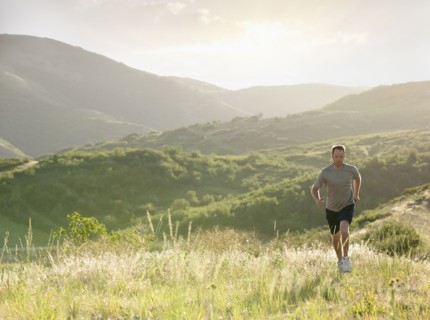 Caucasian man running on remote hill