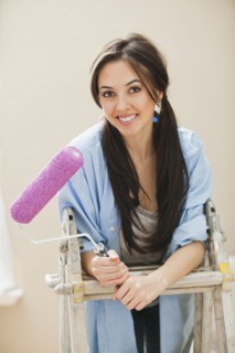 Caucasian woman holding paint roller
