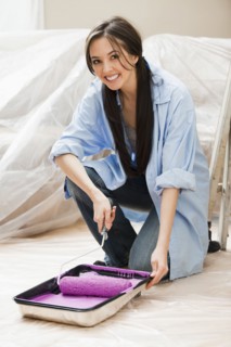 Caucasian woman using paint roller