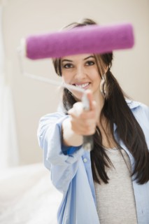 Caucasian woman holding paint roller