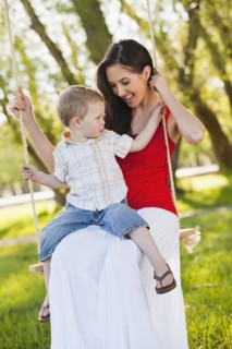 Caucasian mother and son swinging together
