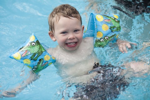 Caucasian boy swimming in swimming pool