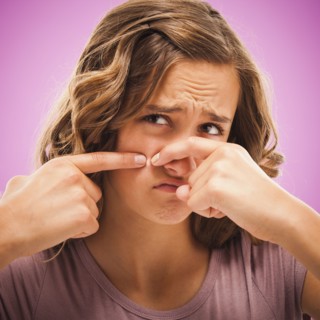 Caucasian teenager popping pimple