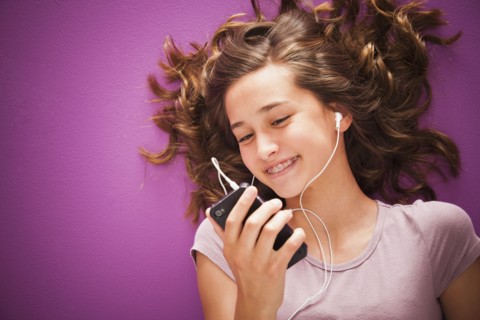 Caucasian teenager listening to music on mp3 player