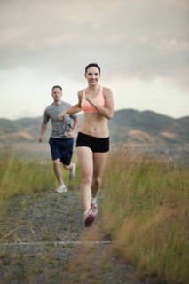 Caucasian couple running together on remote path