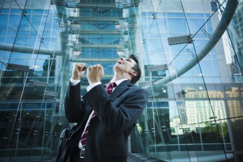 Caucasian businessman cheering outdoors