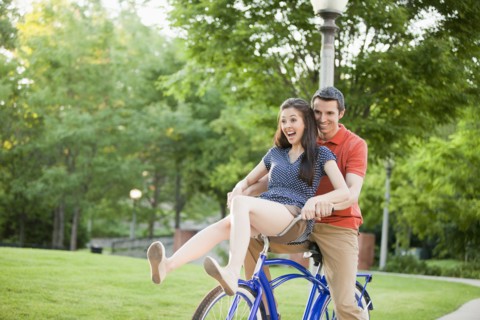 Caucasian couple riding bicycle together