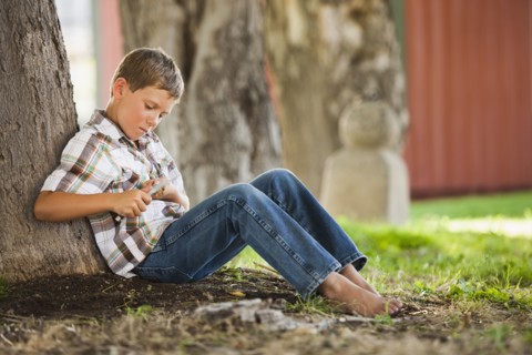 Caucasian boy whittling stick