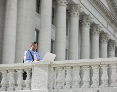 Black businessman using laptop outdoors
