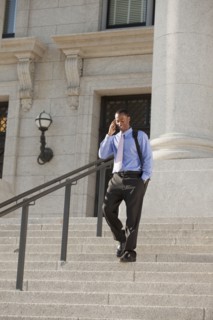 Black businessman talking on cell phone and walking down stairs