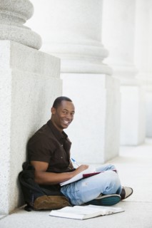 Black college student doing homework outdoor