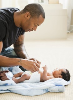 Father changing newborn baby's diaper