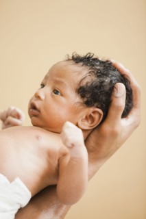 Father cradling newborn baby in hand