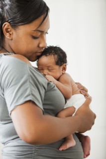 Mixed race mother holding newborn baby