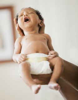 Father cradling newborn baby in hands