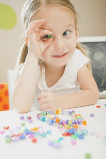 Caucasian girl playing with beads