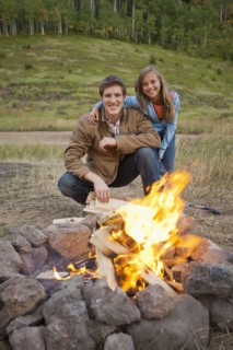 Caucasian couple enjoying campfire