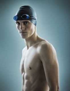 Caucasian teenage boy in swim cap and goggles