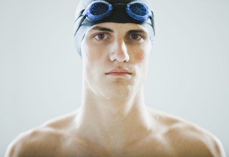 Caucasian teenage boy in swim cap and goggles
