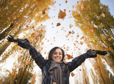 Caucasian woman playing with autumn leaves
