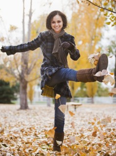 Caucasian woman playing with autumn leaves