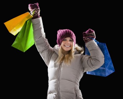 Caucasian woman in coat holding shopping bags