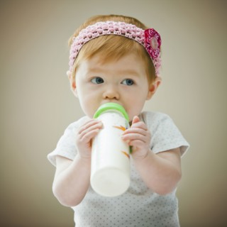 Caucasian baby girl drinking bottle