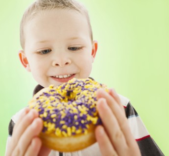 Caucasian boy eating donut