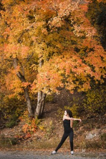Caucasian woman stretching in autumn road