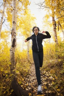Caucasian woman running in autumn forest