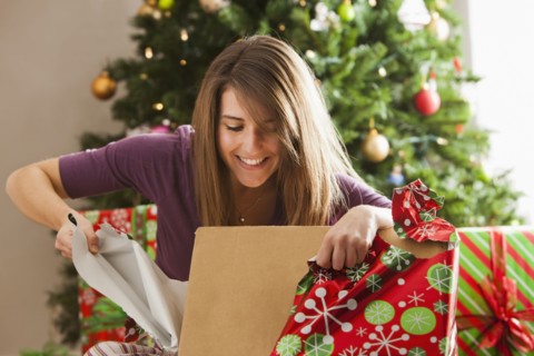 Caucasian woman opening Christmas gift