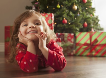 Caucasian girl laying on floor near Christmas tree