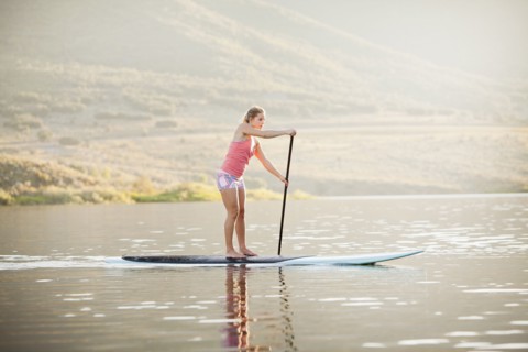 Caucasian woman on stand up paddle board