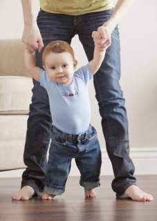 Caucasian mother helping son learn to walk
